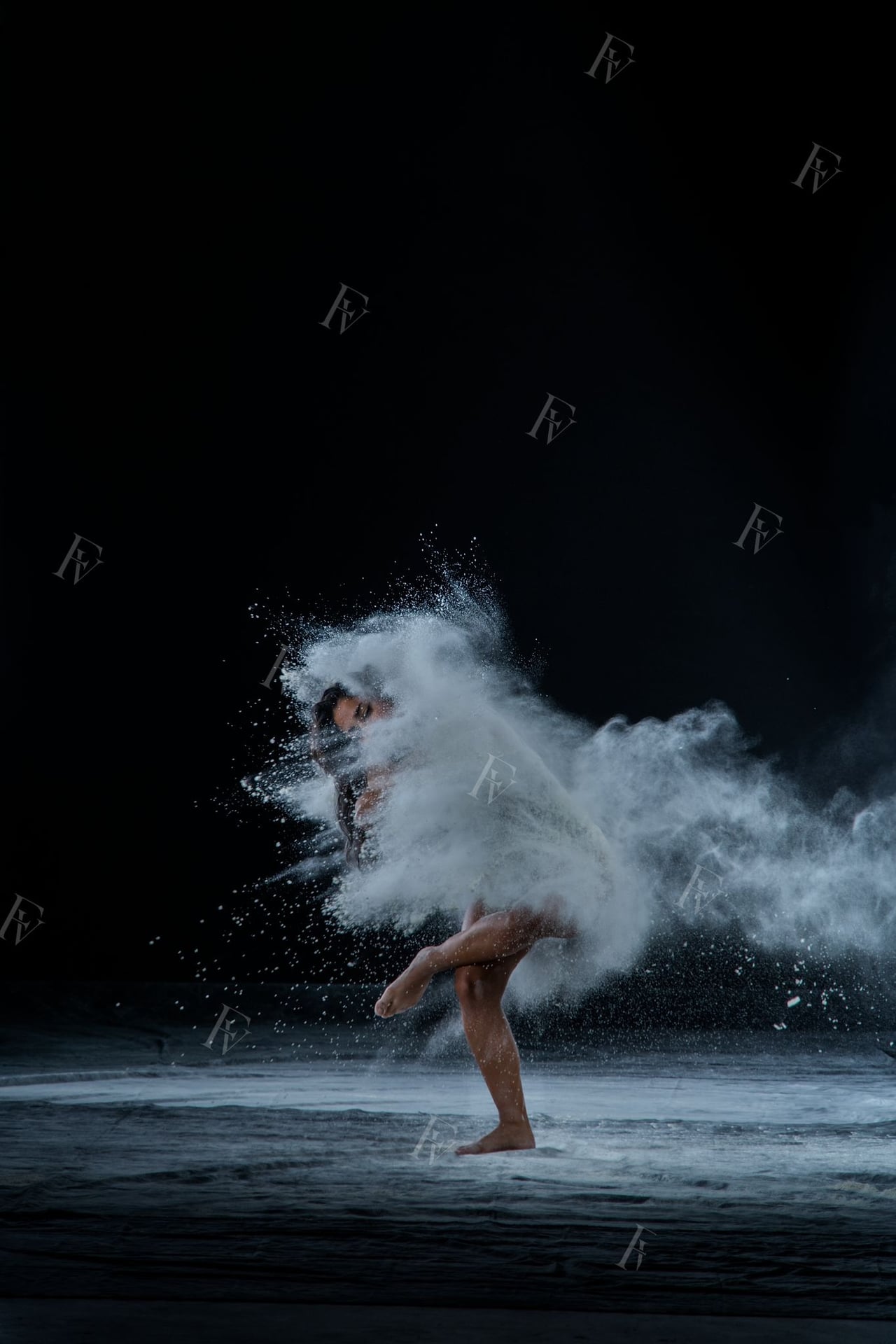 Ballarina amb body en pose amb farina blanca caient, fons d'estudi negre low-key.