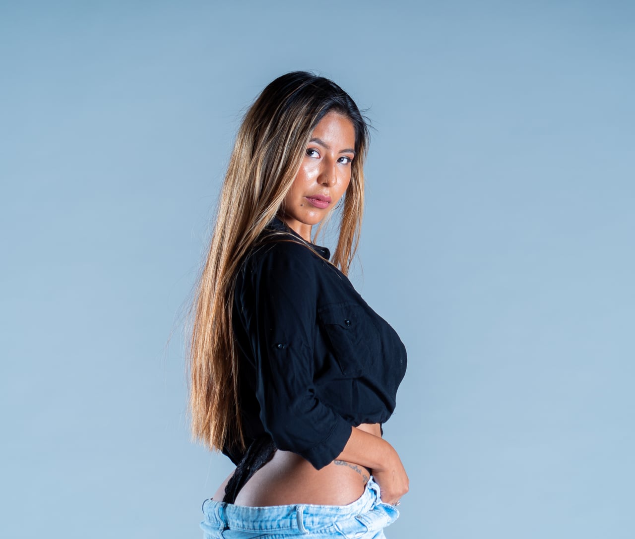 Dona jove en pose editorial estudi, fons d'estudi gris blavós.